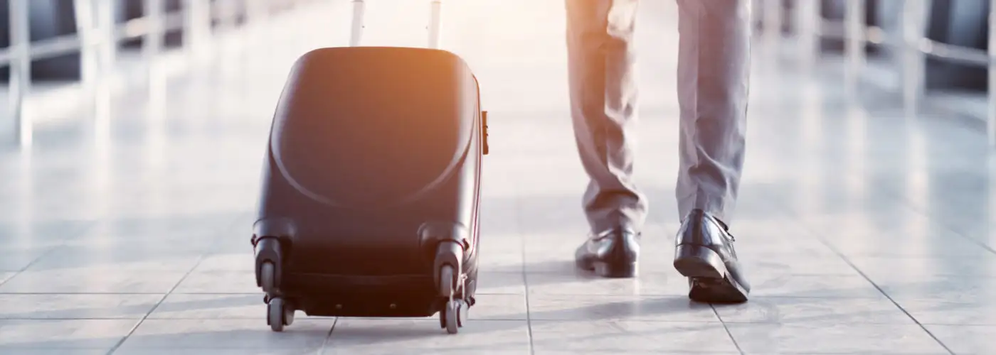 Close up of business man rolling his suitcase down a jetbridge