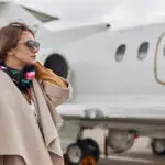 Well-dressed woman standing next to a jet plane