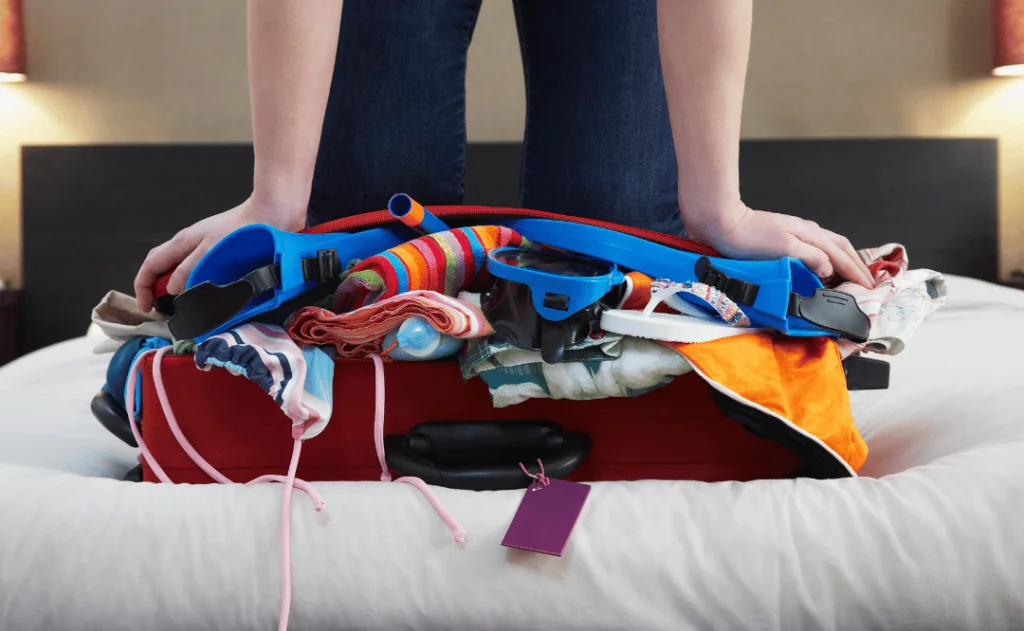 Kneeling On Overstuffed Suitcase