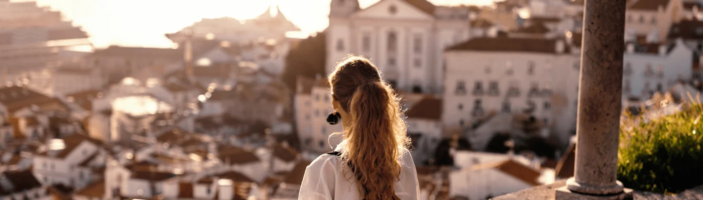 Female tourist looking at old town from balcony