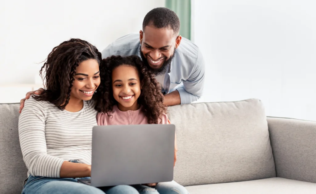 Happy family using laptop in living room