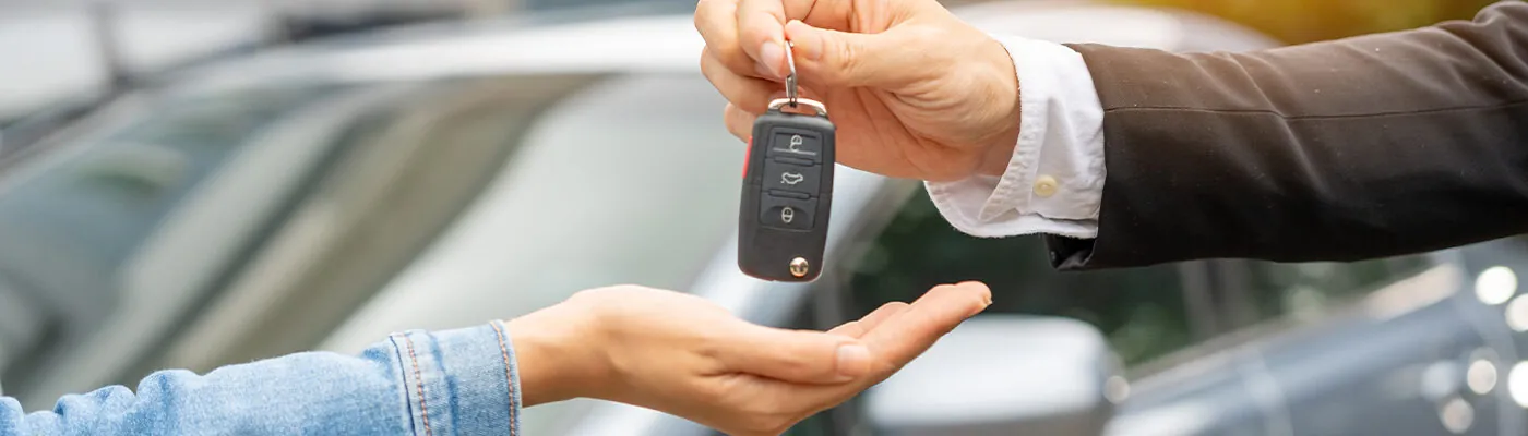 Person handing over the keys to a car rental