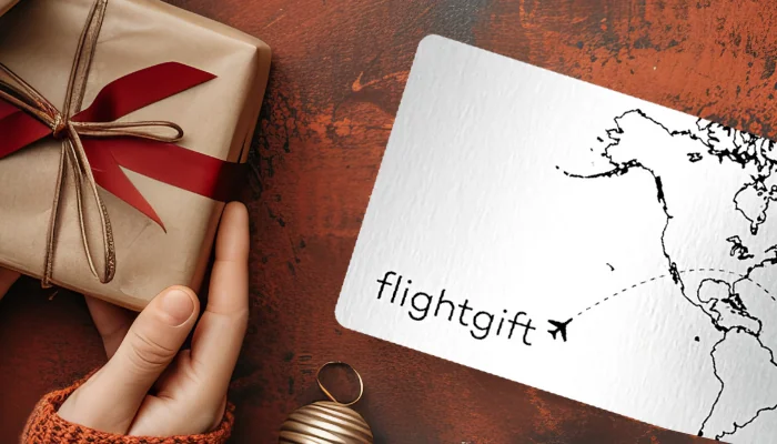 Hands holding Gifts Next to Airline Ticket with World Map - Christmas Themed
